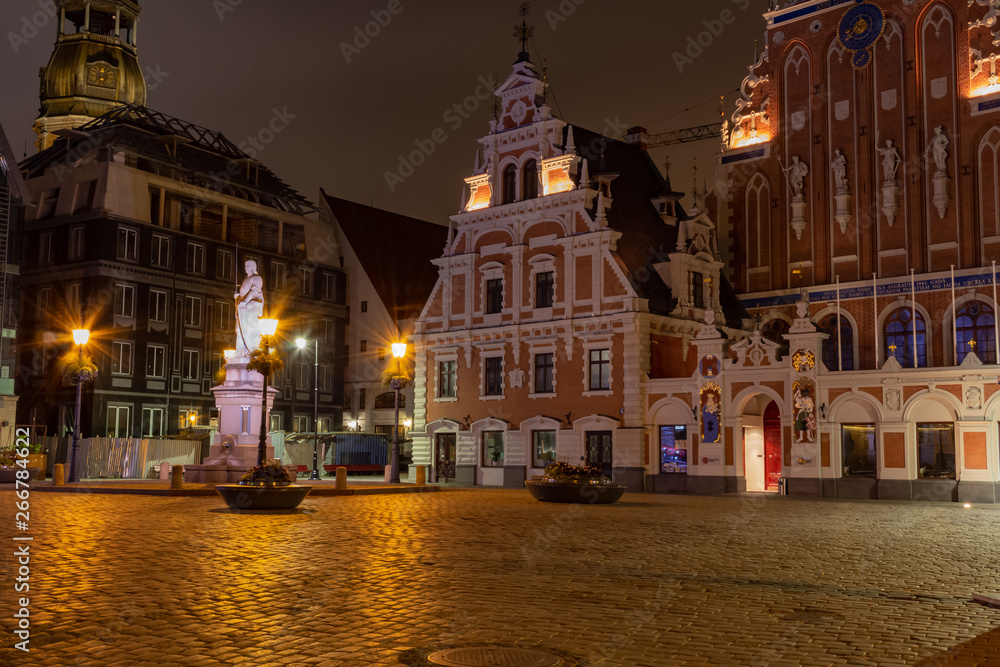 Obraz premium Old Riga the capital of Latvia at night. House of Blackheads in the Town Hall Square and the spire of the Cathedral in the historic center of the old city against background of night sky.