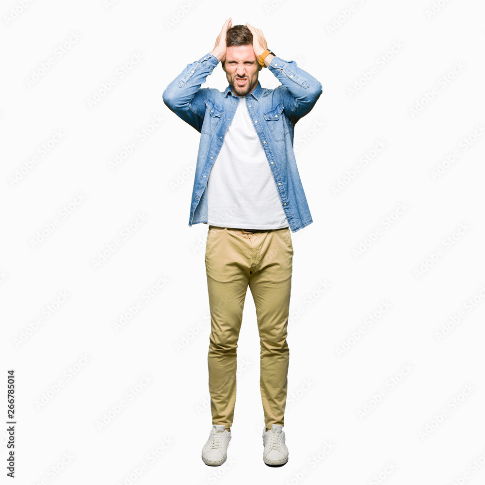 Handsome man with blue eyes and beard wearing denim jacket suffering from headache desperate and stressed because pain and migraine. Hands on head. Handsome man with blue eyes and beard wearing denim jacket suffering from headache desperate and stressed because pain and migraine. Hands on head.
