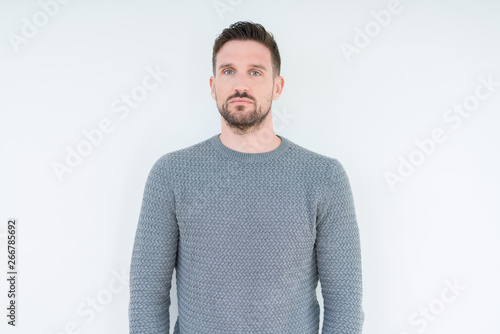 Young handsome man wearing casual sweater over isolated background Relaxed with serious expression on face. Simple and natural looking at the camera.