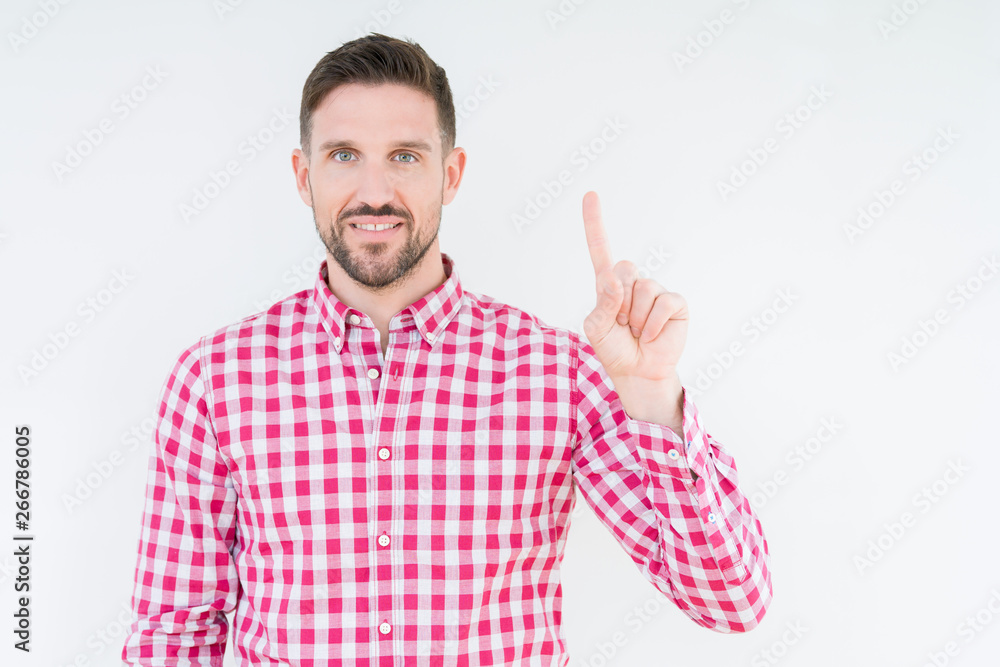 Young handsome man wearing shirt over isolated background showing and pointing up with finger number one while smiling confident and happy. Young handsome man wearing shirt over isolated background showing and pointing up with finger number one while smiling confident and happy.