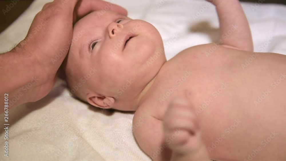 The father gently strokes the newborn child. The father gently strokes the newborn child.