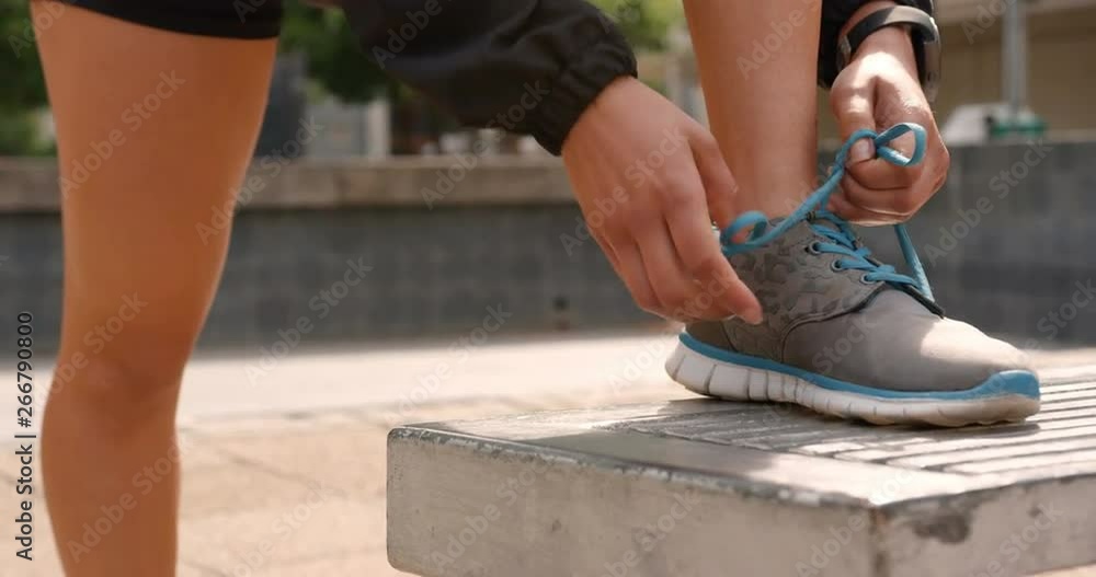 Low section of woman tying shoelaces in the city 4k Low section of woman tying shoelaces in the city 4k