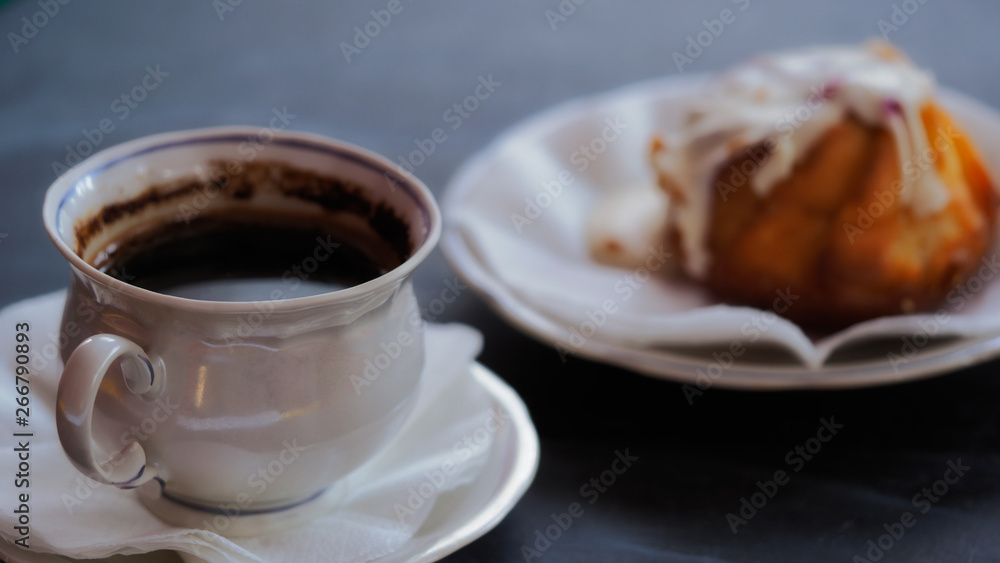 A Cup of coffee and a fresh cake on a saucer. Morning invigorating drink in a cafe or restaurant. Beautiful delicate photo for romanticism. A Cup of coffee and a fresh cake on a saucer. Morning invigorating drink in a cafe or restaurant. Beautiful delicate photo for romanticism.