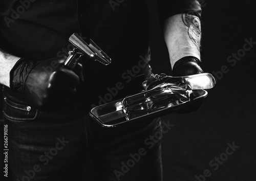 Man with metal speculum (medical). Latex gloves. BDSM concept.