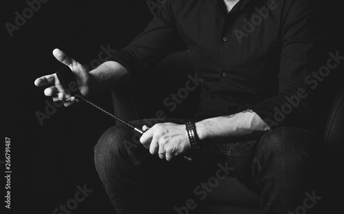 Strict man with bat. BDSM concept.
