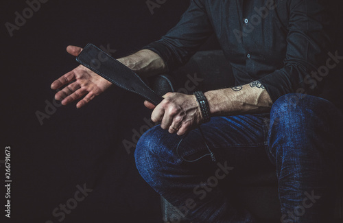 Strict man with paddle. BDSM concept.