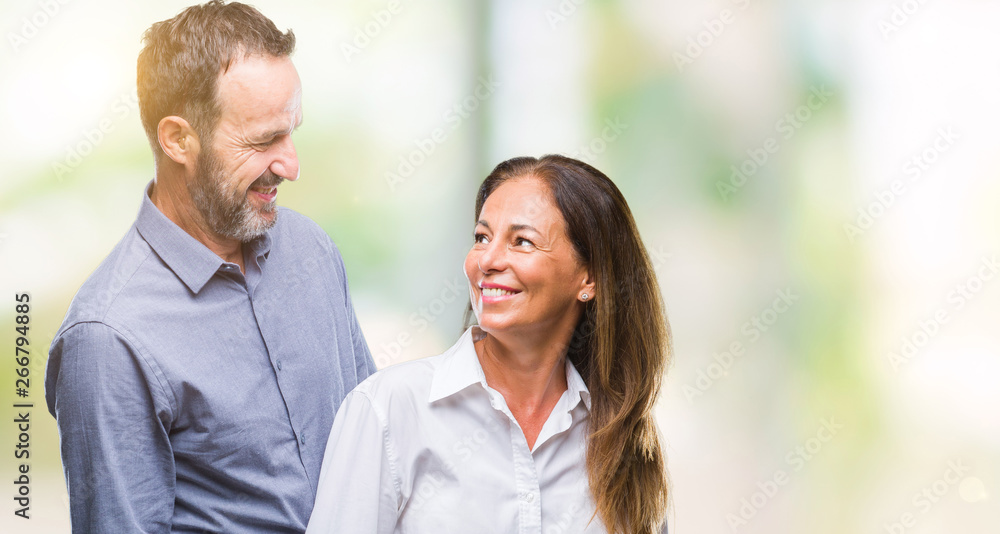 Middle age hispanic business couple over isolated background with serious expression on face. Simple and natural looking at the camera.
