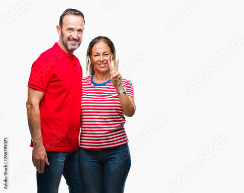 Middle age hispanic couple in love over isolated background showing and pointing up with fingers number two while smiling confident and happy.