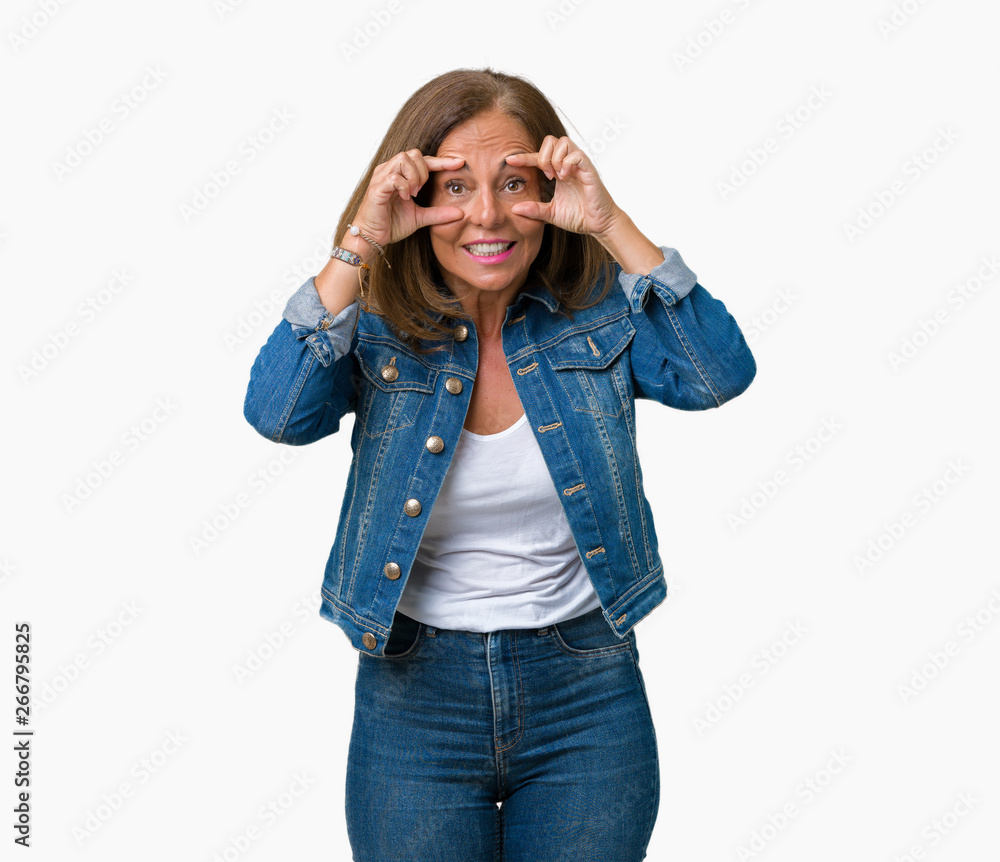 Beautiful middle age woman wearing casual denim jacket over isolated background Trying to open eyes with fingers, sleepy and tired for morning fatigue Beautiful middle age woman wearing casual denim jacket over isolated background Trying to open eyes with fingers, sleepy and tired for morning fatigue