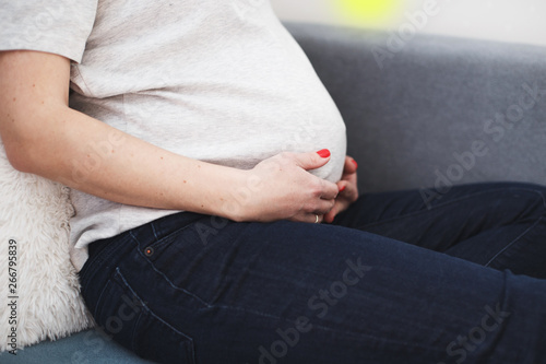 pregnant woman sitting on the sofa. pregnant belly close