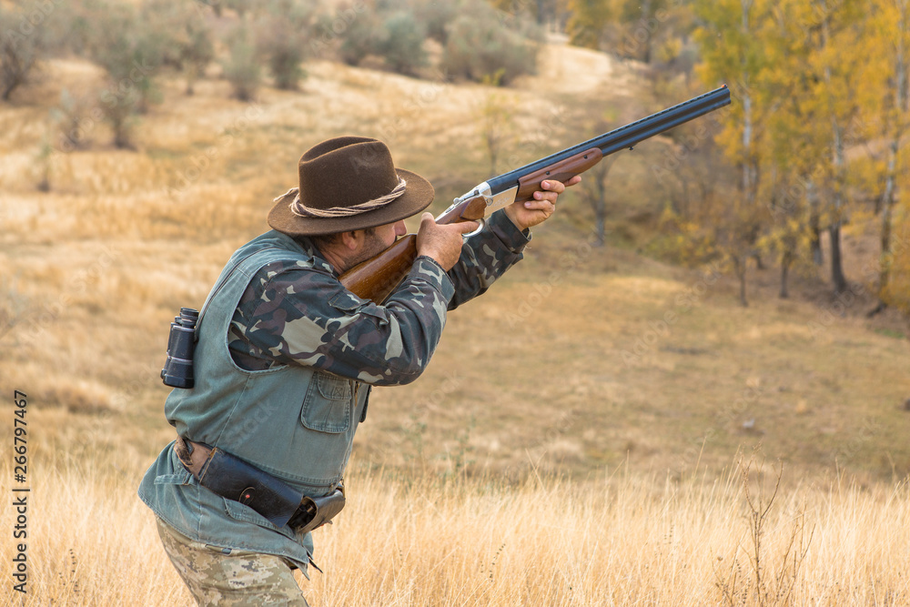 Hunter with a hat and a gun in search of prey in the steppe Hunter with a hat and a gun in search of prey in the steppe