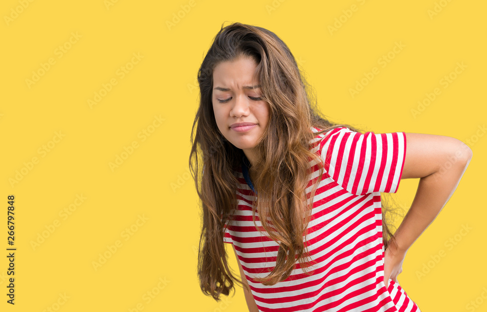 Young beautiful brunette woman wearing stripes t-shirt over isolated background Suffering of backache, touching back with hand, muscular pain Young beautiful brunette woman wearing stripes t-shirt over isolated background Suffering of backache, touching back with hand, muscular pain