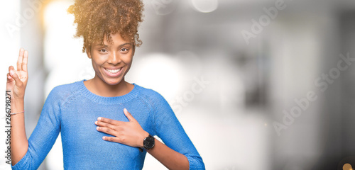 Beautiful young african american woman over isolated background Swearing with hand on chest and fingers, making a loyalty promise oath photo