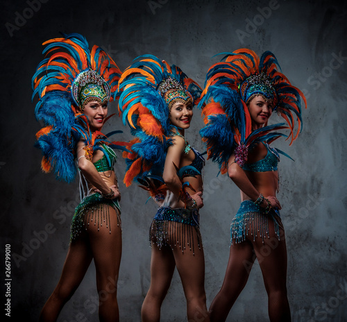 Fotografie Studio portrait of a group professional dancers female in colorful sumptuous carnival feather suits
