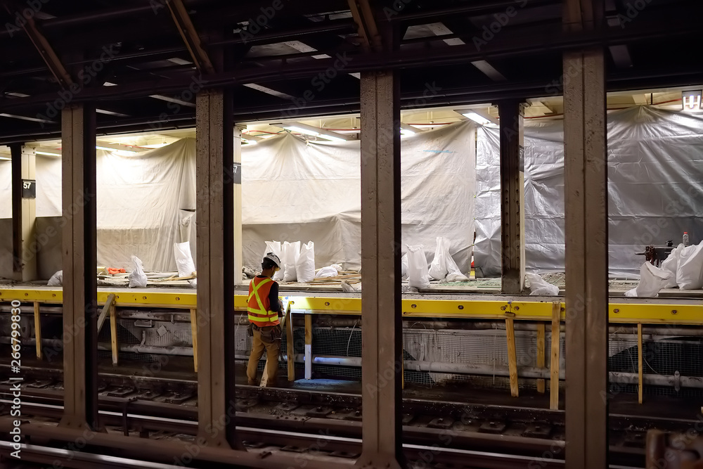 NEW YORK, USA - OCTOBER 22, 2018: Repair in New York subway. MTA worker repairing the platform of the NYC subway station NEW YORK, USA - OCTOBER 22, 2018: Repair in New York subway. MTA worker repairing the platform of the NYC subway station