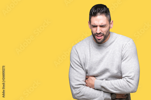 Young handsome man wearing sweatshirt over isolated background with hand on stomach because nausea, painful disease feeling unwell. Ache concept.