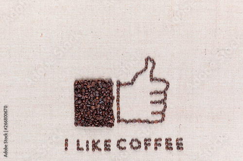 Thumbs up with 'I like coffee' made from coffee beans on linen texture, arranged bottom center.