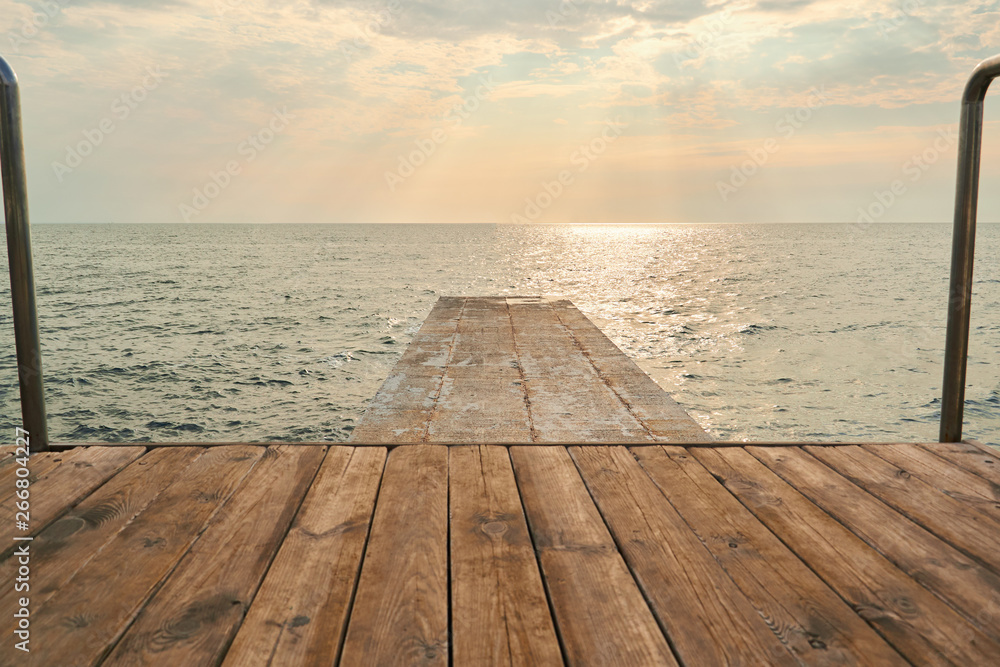 Fototapeta premium Wooden table on sunny day near sea. Sunset