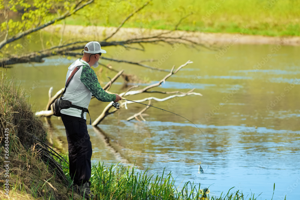 Fisherman trying to do a perfect cast, throwing lure. Spining fishing, angling, catching fish. Hobby and vacation. Photo with shallow depth of field taken at wide open aperture. Fisherman trying to do a perfect cast, throwing lure. Spining fishing, angling, catching fish. Hobby and vacation. Photo with shallow depth of field taken at wide open aperture.