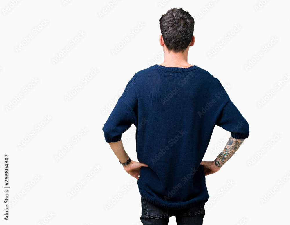 Young handsome man over isolated background standing backwards looking away with arms on body Young handsome man over isolated background standing backwards looking away with arms on body