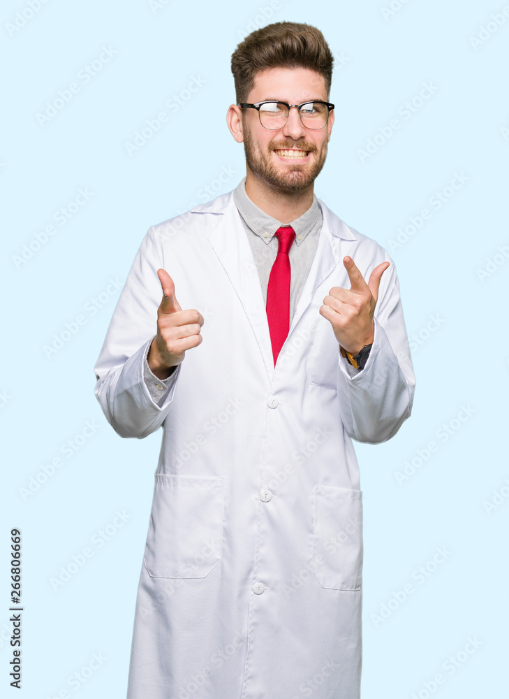 Young handsome scientist man wearing glasses pointing fingers to camera with happy and funny face. Good energy and vibes. Young handsome scientist man wearing glasses pointing fingers to camera with happy and funny face. Good energy and vibes.