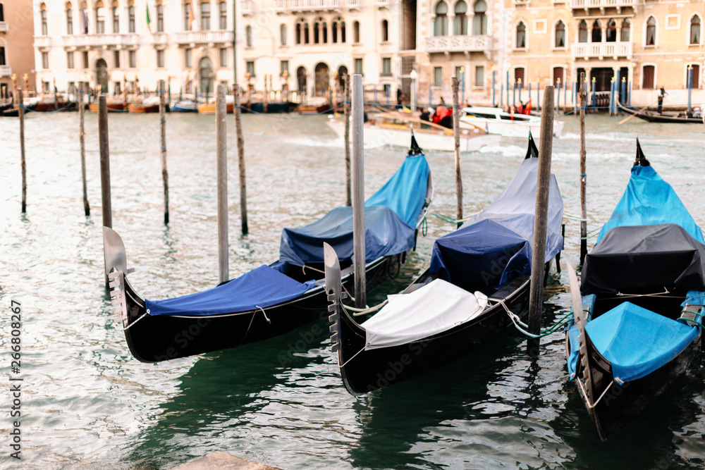 gondolas with rain covers sit in the canal in venice italy