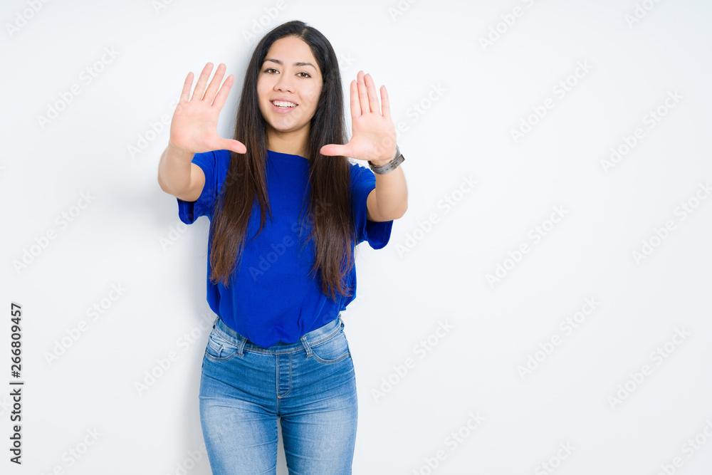 Beautiful brunette woman over isolated background Smiling doing frame using hands palms and fingers, camera perspective