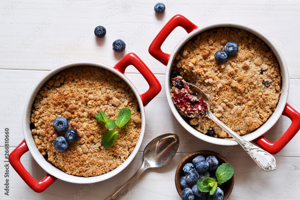 Crumble with blueberries on a white kitchen table. View from above. Crumble with blueberries on a white kitchen table. View from above.