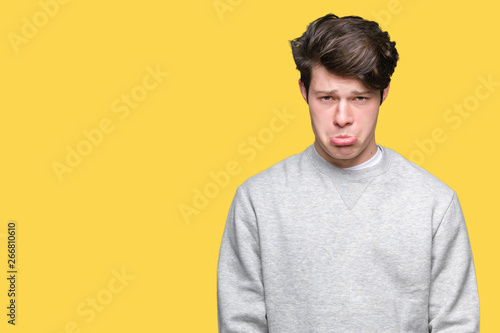 Young handsome sporty man wearing sweatshirt over isolated background depressed and worry for distress, crying angry and afraid. Sad expression.