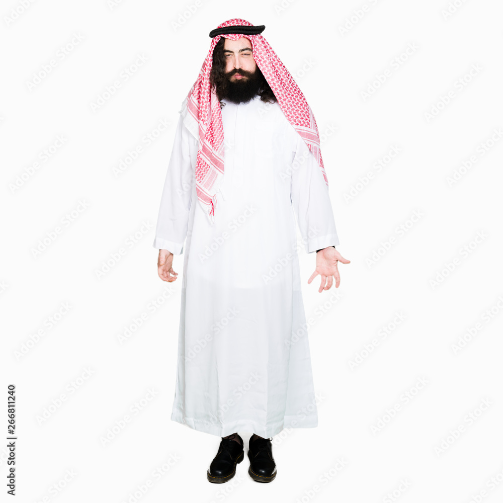 Arabian business man with long hair wearing traditional keffiyeh scarf puffing cheeks with funny face. Mouth inflated with air, crazy expression. Arabian business man with long hair wearing traditional keffiyeh scarf puffing cheeks with funny face. Mouth inflated with air, crazy expression.