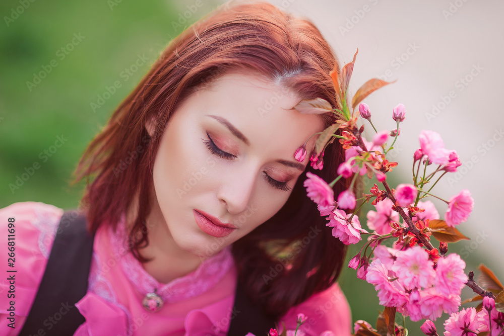 Beautiful woman in the garden of sakura. Retro clothes, pink blouse. Beautiful woman in the garden of sakura. Retro clothes, pink blouse.