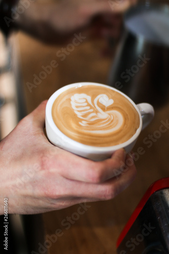 barista man preparing coffee  cappuccino with a swan latte art   pouring milk