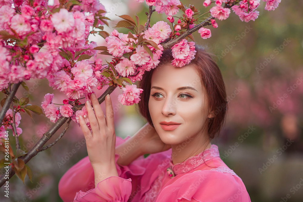 Fototapeta premium Beautiful woman in the garden of sakura. Retro clothes, pink blouse.