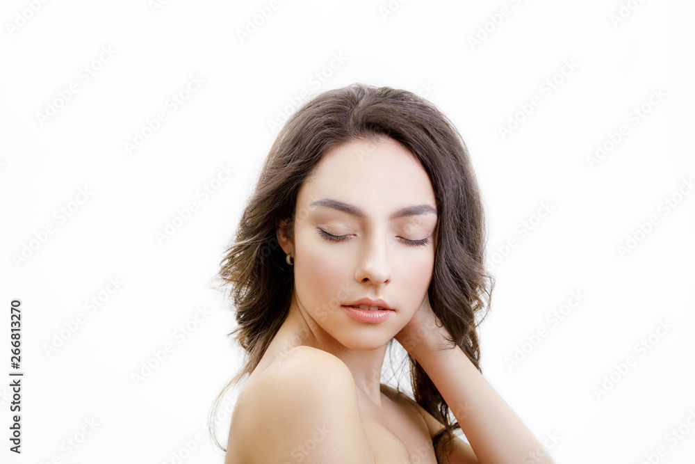Closeup studio portrait of young tender woman. Girl has long brown hair with curls. Her eyes are closed. Relaxation after skin care and spa. Isolated on white background. Closeup studio portrait of young tender woman. Girl has long brown hair with curls. Her eyes are closed. Relaxation after skin care and spa. Isolated on white background.