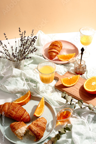 Croissants and oranges on a blue tablecloth