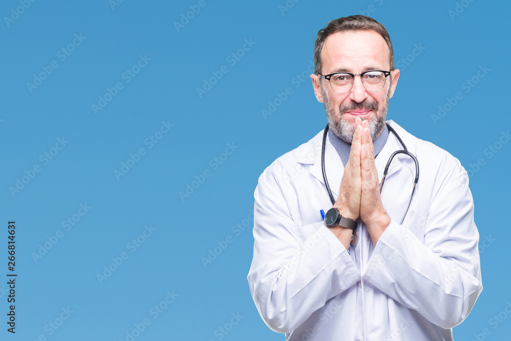Middle age senior hoary doctor man wearing medical uniform isolated background praying with hands together asking for forgiveness smiling confident. Middle age senior hoary doctor man wearing medical uniform isolated background praying with hands together asking for forgiveness smiling confident.