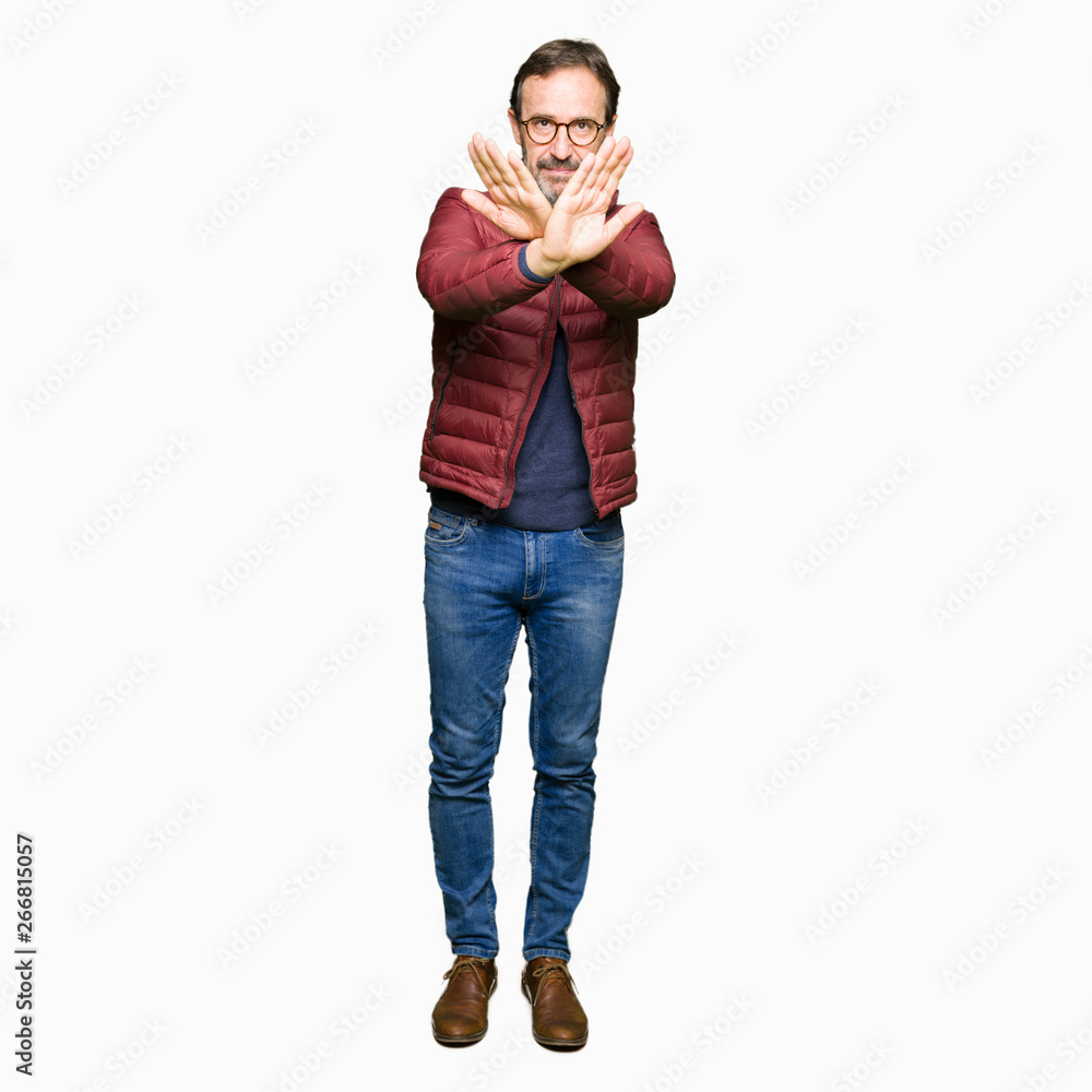 Middle age handsome man wearing glasses and winter coat Rejection expression crossing arms and palms doing negative sign, angry face Middle age handsome man wearing glasses and winter coat Rejection expression crossing arms and palms doing negative sign, angry face