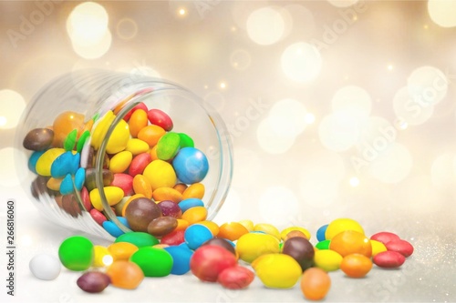 Colorful candies sweets falling out of a glass jar  composition isolated over the white background