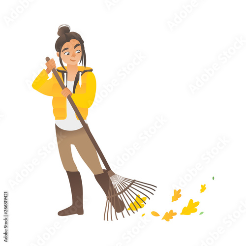 A cute girl or young woman sweeps the leaves with a rake.