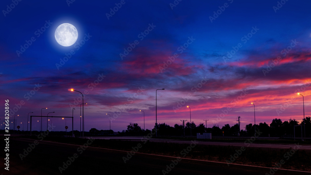  The colourful sky with a cloud and a bright full moon over the highway. Tranquility of the nature background.