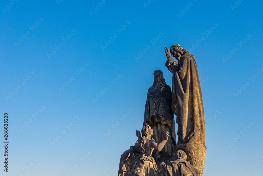 Fototapeta premium Beautiful delicate and elaborate sandstone Christian religion sculpture, Statues of Saints Cyril and Methodius, placed on the balustrade of Charles Bridge, Karlův most, in Prague, Czech Republic.