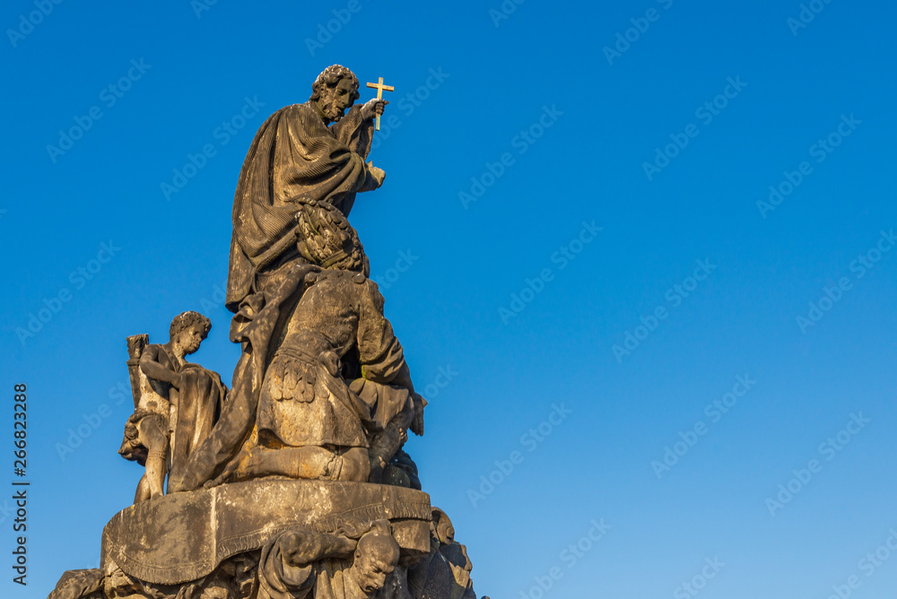 Beautiful delicate and elaborate sandstone Christian religion sculpture, statue of Saint Francis Xaverius, placed on the balustrade of Charles Bridge, Karlův most, in Prague, Czech Republic.