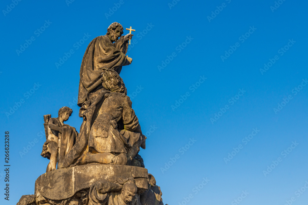 Obraz premium Beautiful delicate and elaborate sandstone Christian religion sculpture, statue of Saint Francis Xaverius, placed on the balustrade of Charles Bridge, Karlův most, in Prague, Czech Republic.