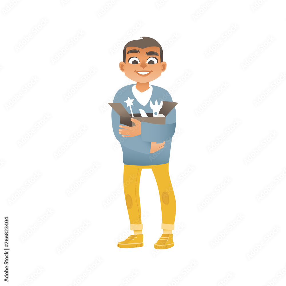 A boy in jeans, sweaters and sneakers holds a box with children toys. A boy in jeans, sweaters and sneakers holds a box with children toys.