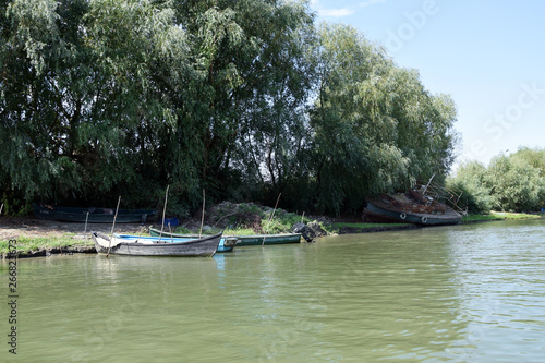 Fishing boat and old abandoned fishing ship on the river bank. Danube Delta  Romania.