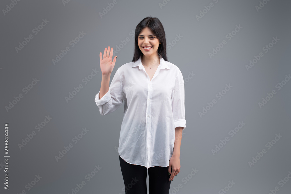 Attractive young brunette woman isolated on grey background Attractive young brunette woman isolated on grey background