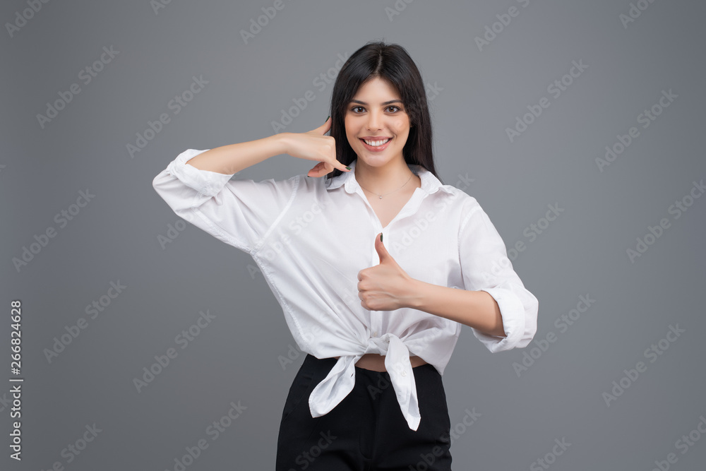 Attractive young brunette woman isolated on grey background Attractive young brunette woman isolated on grey background