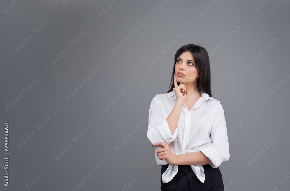 Attractive young brunette woman isolated on grey background Attractive young brunette woman isolated on grey background