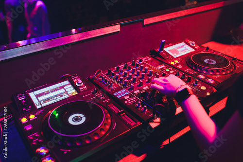 Fotografie, Obraz DJ turntable console mixer controlling with two hand in concert nightclub stage