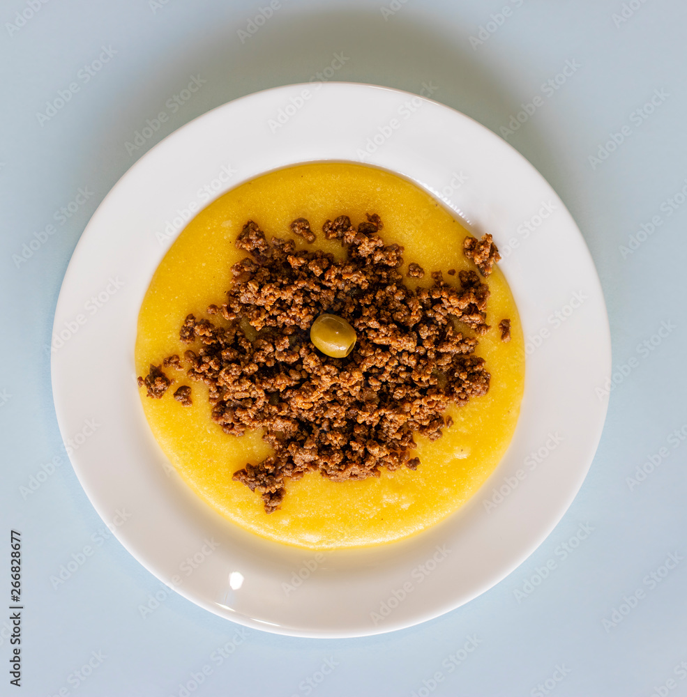 Polenta meal with ground beef, on white plate. Polenta meal with ground beef, on white plate.